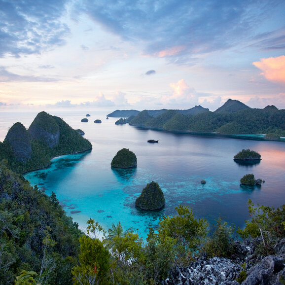 Turquoise waters and limestone islands at sunset at Amandira, Raja Ampat.