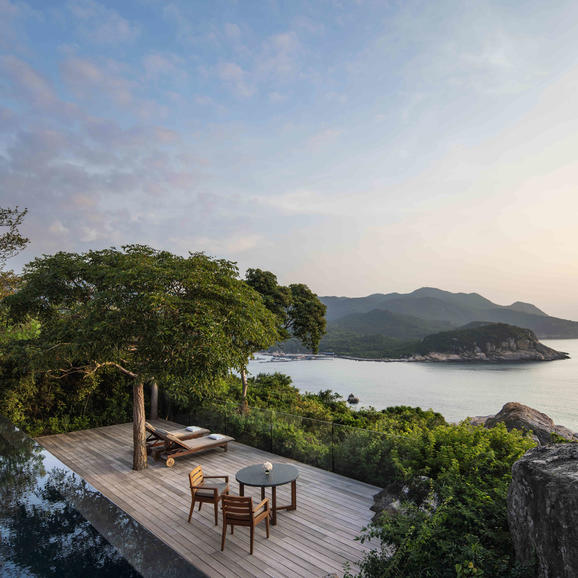 Square Ocean Villa terrace at Amanoi with dining furniture overlooking tropical coastline and distant mountains.