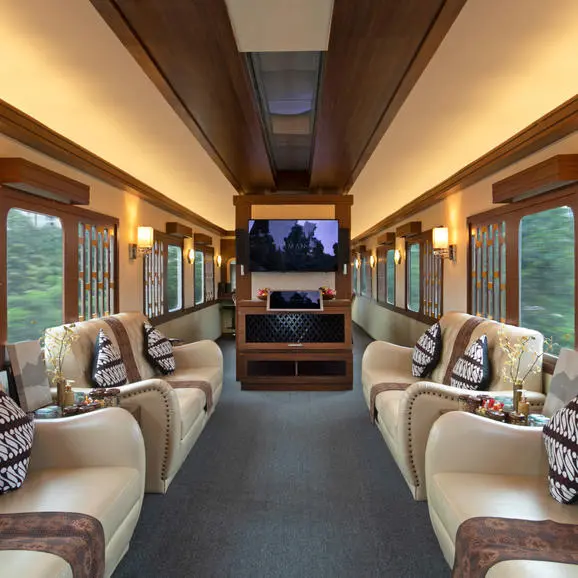 Interior of Amanjiwo's private train carriage with cream upholstered seating and warm overhead lighting.