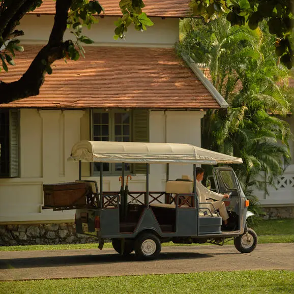 Tuk-tuk parked outside Amantaka resort in Laos, ready for guest transportation.