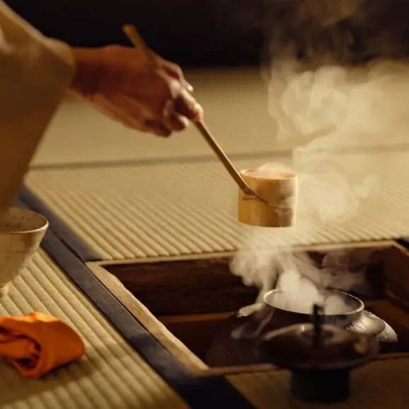 Cyanoyu bath ritual at Aman Kyoto resort, hand pouring hot water over wooden bathing vessel.