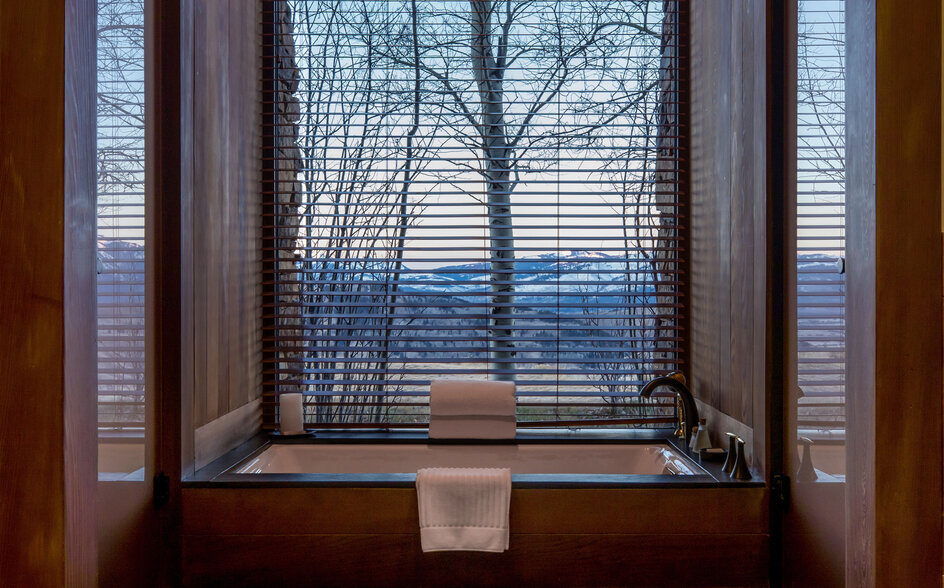 Deluxe Suite window seat at Amangani overlooking snow-covered landscape at dusk.