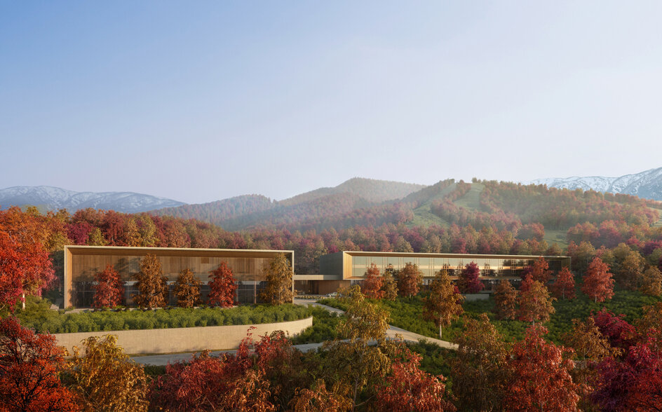 Aman Niseko retreat exterior nestled amongst autumn foliage with mountain backdrop.