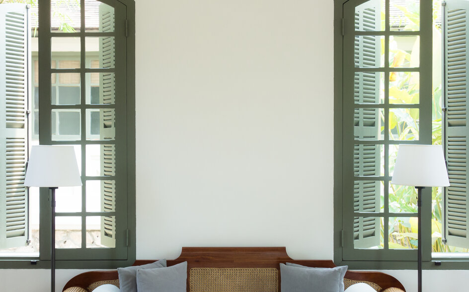 Light-filled seating area at Amantaka with arched windows overlooking the gardens.