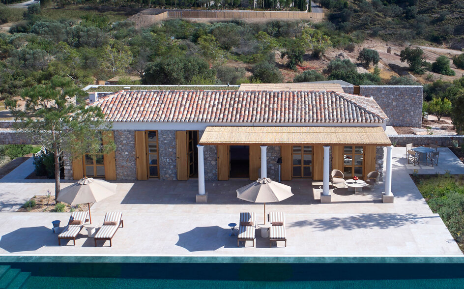 Villa with terracotta roof and plunge pool overlooking turquoise waters at Amanzoe resort.