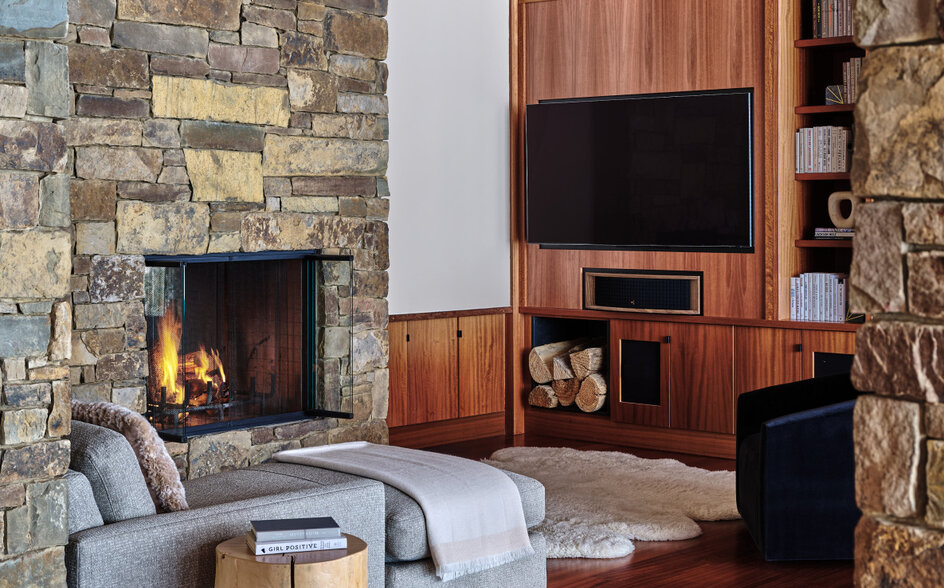 Wapiti home at Amangani featuring stone fireplace, wooden-beamed ceiling, and seating area with hardwood flooring.