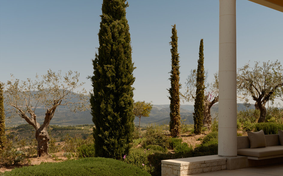Pool pavilion at Amanzoe with cypress trees and Aegean views.