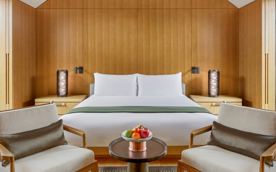 Ming courtyard suite bedroom at Amanyangyun with wooden panelled walls and symmetrical seating.