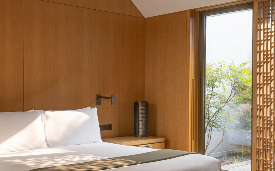 Ming-style courtyard guest room at Amanyangyun with wooden panelling and platform bed.