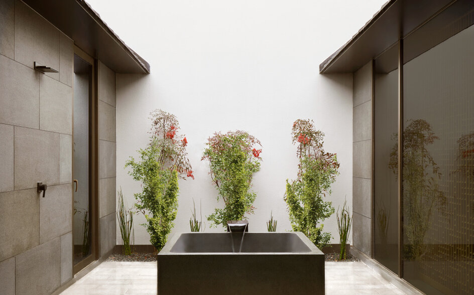 Outdoor jacuzzi at Amanyangyun surrounded by potted plants and stone walls, China.
