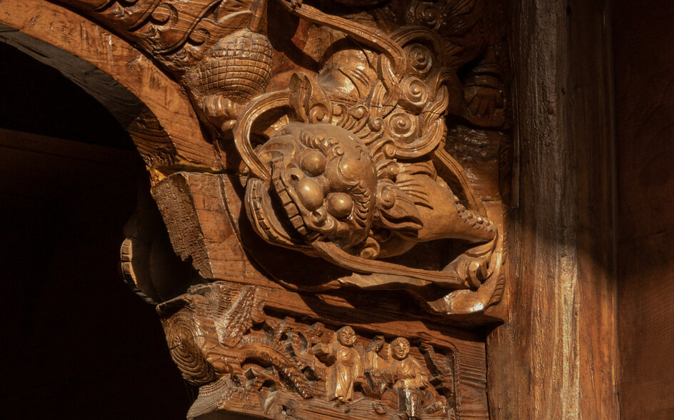 Carved wooden architectural detail at Amanyangyun, China, featuring ornate dragon motif.