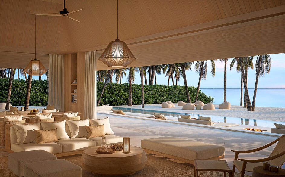 Beach pavilion at Amanzoe with open sides, neutral furnishings, and sea views beyond.