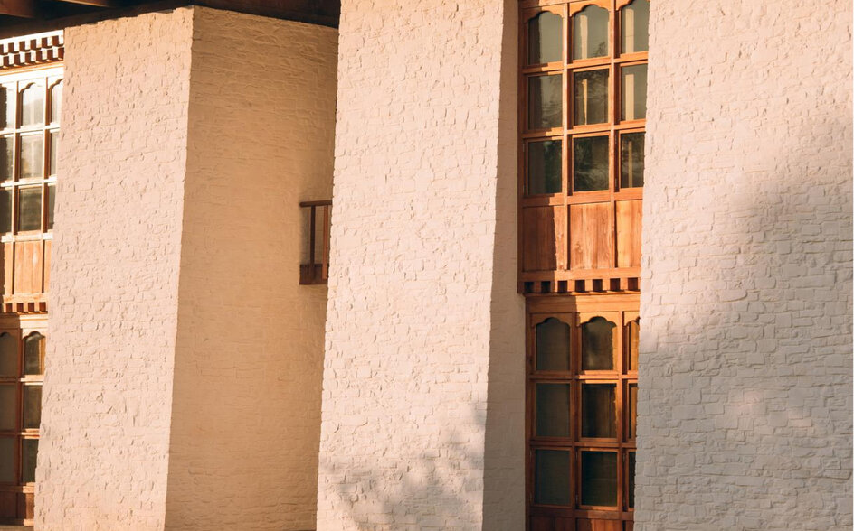 Amankora accommodation building in Bumthang with whitewashed walls and wooden window shutters.