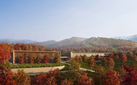 Aman Niseko retreat exterior nestled amongst autumn foliage with mountain backdrop.