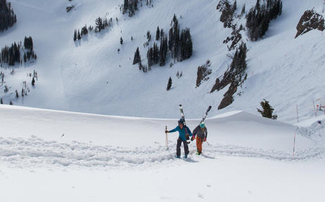 Ski concierge team with guests on snowy mountain slope at Amangani.