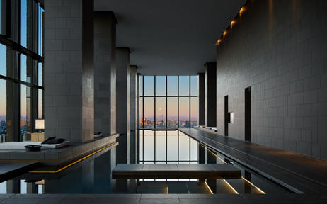 Aman Tokyo wellness spa pool overlooking the city skyline at dusk.