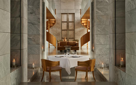 Salle à manger privée élégante à Amanzoe, avec table centrale et chaises en bois doré.