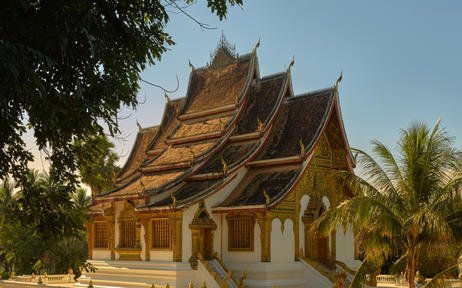 Golden-roofed temple at Amantaka with ornate peaked eaves and tropical surroundings.