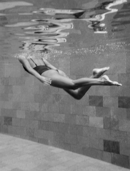 Person floating in the pool at Aman Miami Beach, black and white photograph.