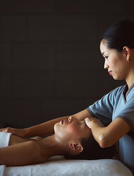 Therapist administering a relaxing facial massage at Aman Tokyo wellness centre.