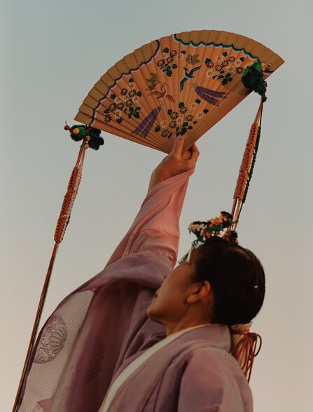 Person holding decorative umbrella with patterned fabric at Amanemu, Japan.