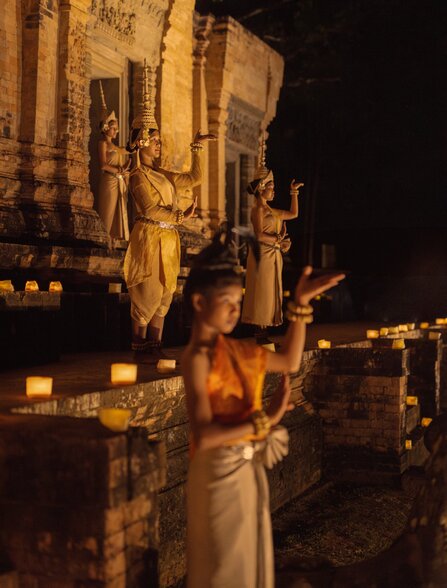 Candlelit Apsara dancer in traditional costume at Amansara's festive temple dinner in Cambodia.