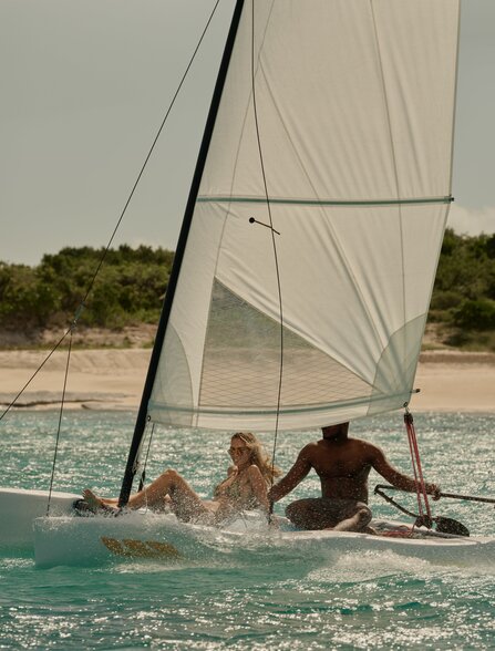 Guests sailing a Hobie Cat in turquoise waters at Amanyara, Turks and Caicos.
