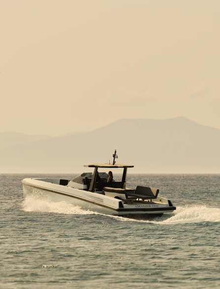 Powerboat gliding across calm Aegean waters near Amanzoe, Greece.