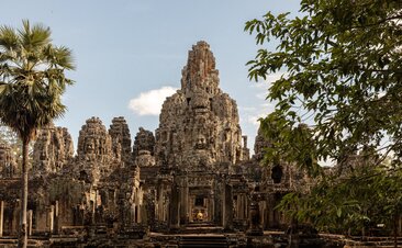 Bayon Temple's stone towers rise amongst tropical vegetation at Amansara's Angkor Temple Tour.