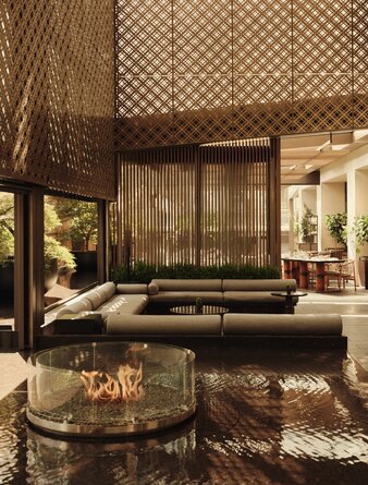 Terrace at Aman New York with wooden screens, low seating, and fireplace glowing at dusk.