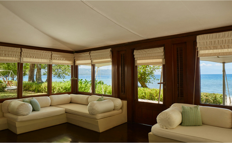 Ocean Tent living area at Amanwana with cream seating and views towards the sea.