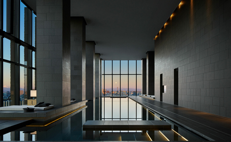 Gallery corridor at Aman Tokyo with floor-to-ceiling windows overlooking the city skyline.