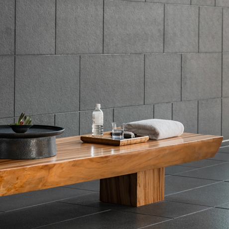 Wooden spa treatment table with folded towels and bottles at Aman Tokyo gallery.