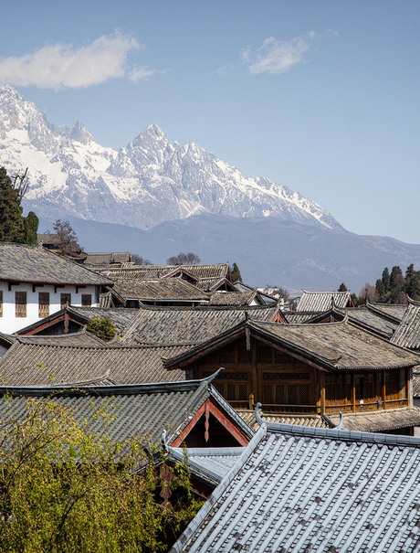 Amandayan's traditional architecture with snow-capped mountain backdrop and verdant gardens.