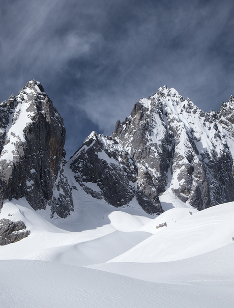 Snow-covered mountain peaks at Amandayan beneath a dramatic sky.