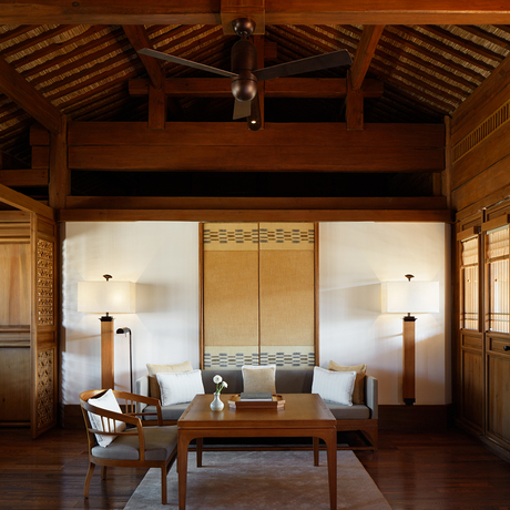 Wooden meditation pavilion at Amandayan with shoji screens, dark timber beams, and minimalist furnishings.