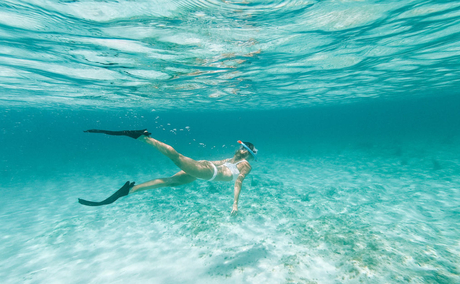アマンヤラ リゾートで、透き通ったターコイズブルーの海を泳ぐシュノーケラー。