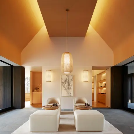 Amanemu resort spa entry with symmetrical cream seating, warm ceiling lights, and dark doorways on either side.