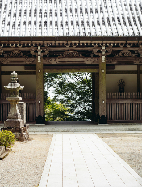 Wooden temple gateway with white floor leading to garden at Amanemu resort.