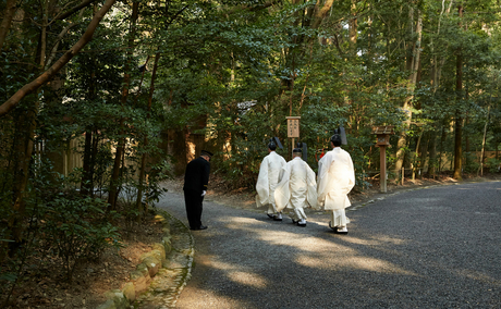 Guests walking along a tree-lined pathway at Amanemu resort.