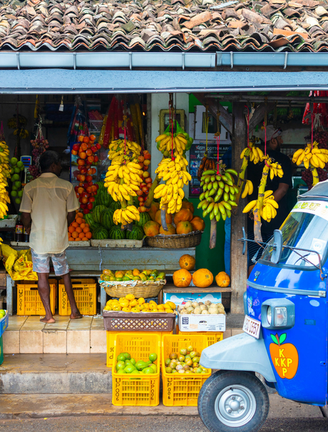 Amangalla flower stall displaying vibrant yellow blooms and orange marigolds from a blue street vendor cart.