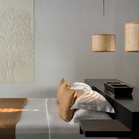 Guest resting on a daybed beneath pendant lights in a spa treatment room at Amansara.