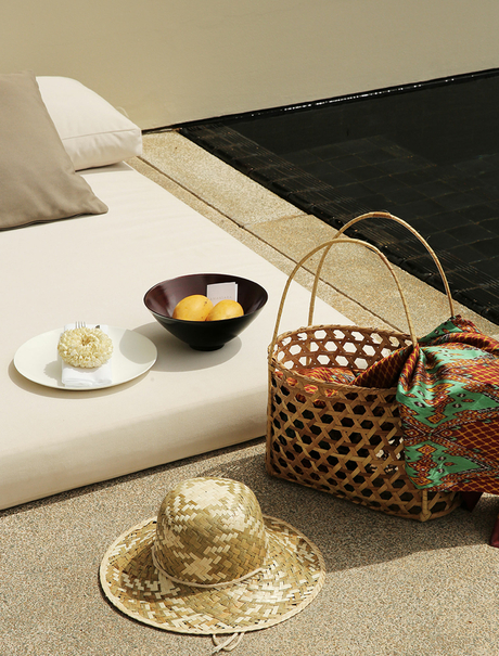 Amansara bedroom detail with woven basket, decorative hat and bedside offerings.