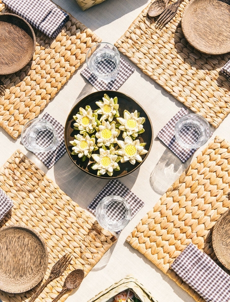Overhead view of a plated salad at Amansara, surrounded by place settings and woven textiles.