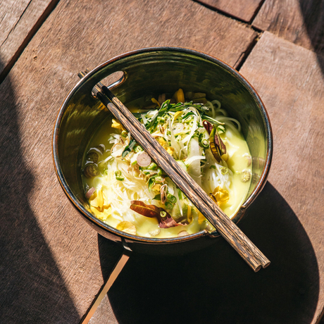 Bowl of noodle soup with chopsticks at Amansara, viewed from above.