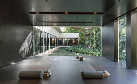 Amansara's spa pavilion with polished concrete floor, minimalist seating, and open sides overlooking gardens.