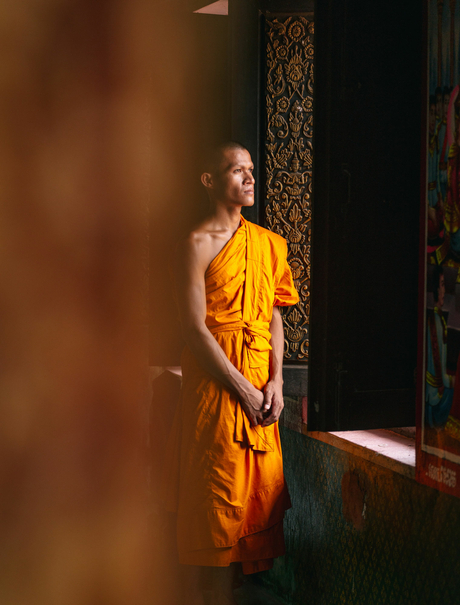 Buddhist monk in saffron robes standing in doorway at Amansara.