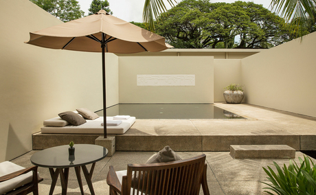 Amansara spa relaxation area with plunge pool, parasol, and potted plants.