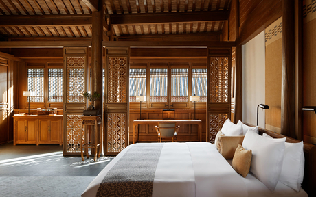 Principal bedroom at Amandayan with wooden architectural features and sheer window panels.