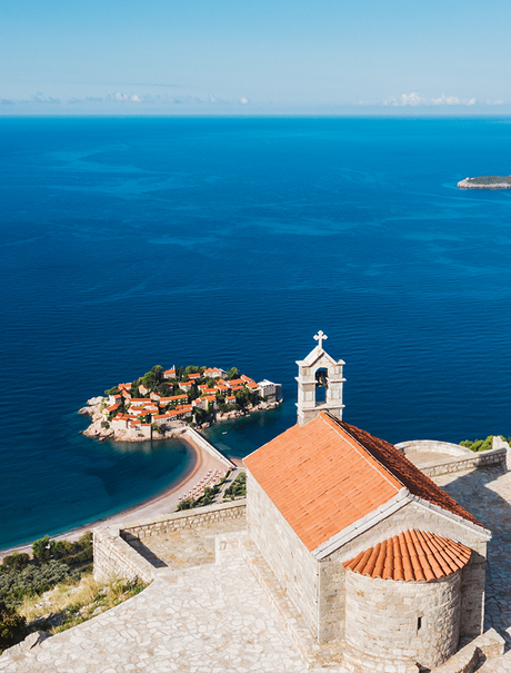 Terracotta-roofed chapel overlooking Aman Sveti Stefan's fortified island and Adriatic Sea.